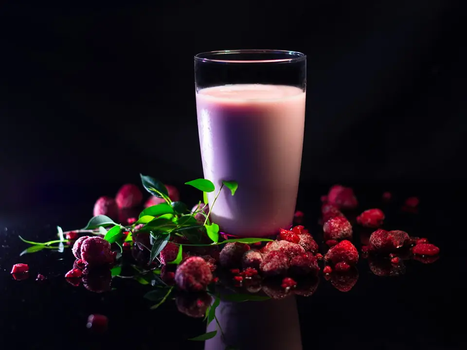 Copo de milkshake rosado com frutas vermelhas