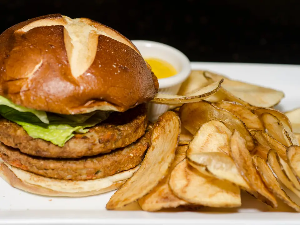 Hambúrguer vegetariano duplo no pão pretzel com chips de batata